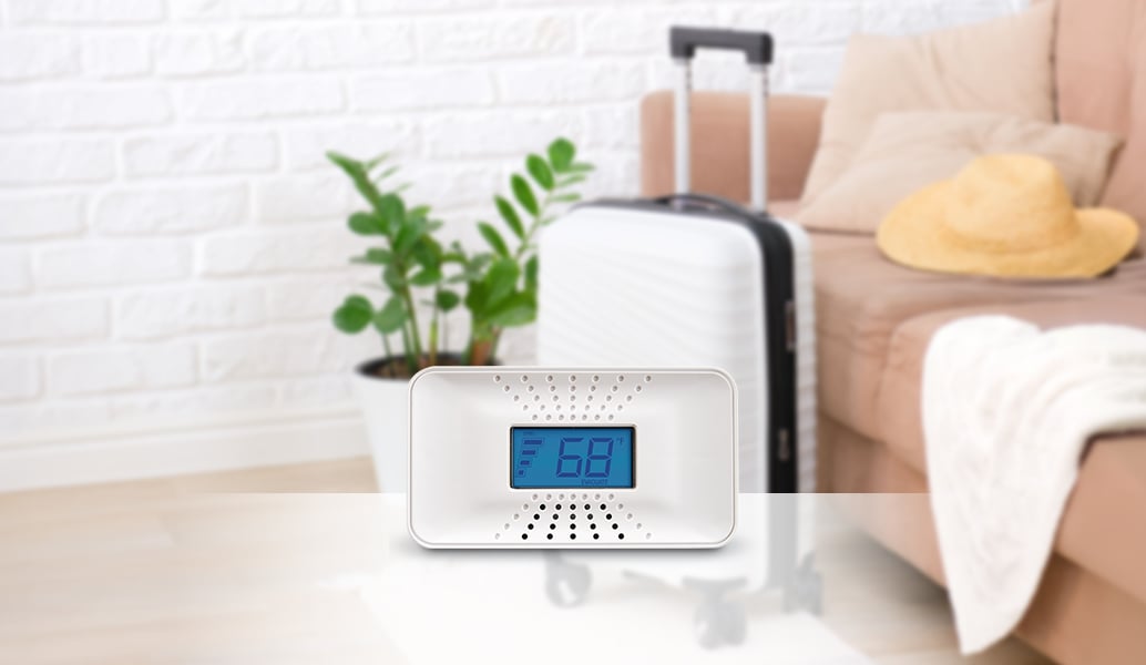 CO alarm with luggage in background