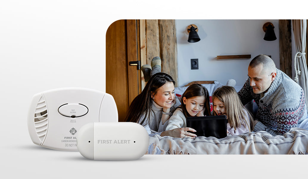 Family laying on bed with CO alarm and Water Leak alarm overlayed 