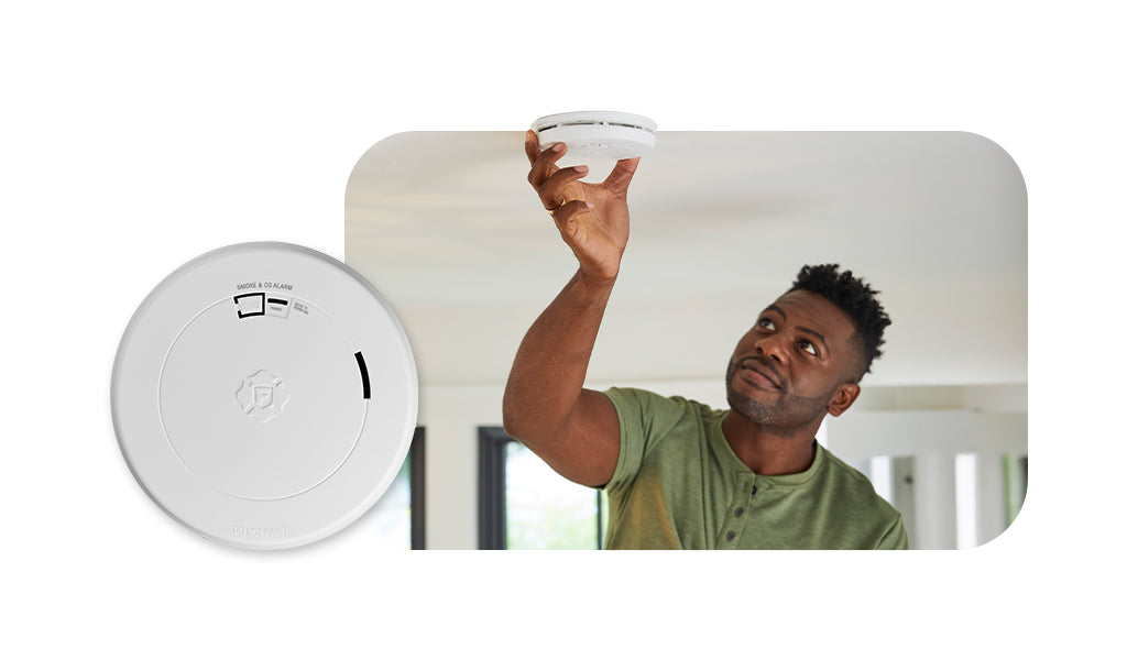 Man installing smoke alarm on ceiling